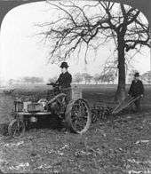 A black-and-white photo of a man on an (1902 model) "Ivel" tractor