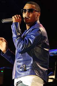 A man performing with a purple jacket and sunglasses