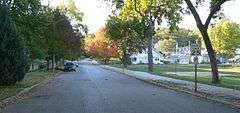 Street with trees on left, small park on right