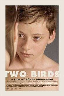 "TWO BIRDS, A FILM BY RÚNAR RÚNARSSON" appears below a photograph of two young, unclothed adolescents, a boy and a girl, shown from the shoulders up. They are gazing into each others eyes. The boy is facing towards the camera, so all but the right edge of his face is visible. His expression is solemn. The girl is on the left side of the picture, with her body at a right angle to the camera and her head turned to her left to face toward the boy. Therefore, we can see only her right ear, her right cheek, and little bits of her right shoulder and of her hair. The two of them have pale skin and dark blond hair. The background behind the boy's head and shoulders is dark gray. The name of the film is in large white letters, which run off the left and right edges of the picture. The rest of the caption is in smaller, dark gray letters, and below it are five lines of additional film credits in very small dark gray letters. All the lines of writing are on a beige background, which blends into their skin.