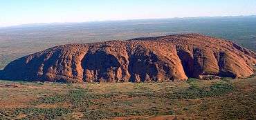 Uluru – a long, low mountain against a flat Australian plain