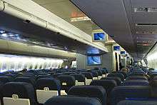 Aircraft main cabin with two aisle and multiple seat rows.