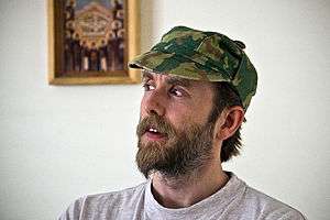 Vikernes looking aside, wearing a camouflage hat