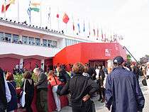 A line outside the entrance to the 2010 Venice International Film Festival with flags of several countries waving above the door