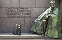 "A green statue of a man wrapped in a cloak alongside a statue of a Scottish Terrier."
