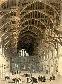 A very large room, with a high vaulted ceiling, mostly empty save for a few small groups of people.