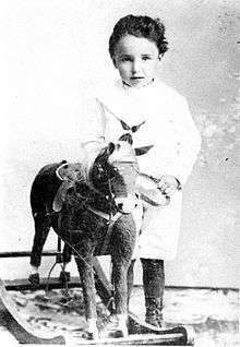 monochrome photograph of a child with a rocking horse