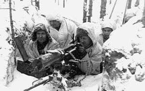 A group of soldiers in snowsuits manning a heavy machine gun