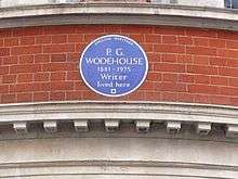 round blue plaque marking Wodehouse's residence, reading: P.G. Wodehouse, 1881–1975: Writer, lived here