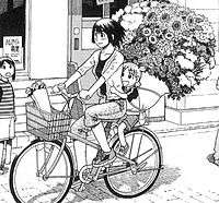 A section of a page from the manga. Two girls ride a bike, with the older one steering and the other clinging to her from behind; the younger one has an enormous bundle of various flowers larger than her strapped to her back. In the background, a girl stares at them.